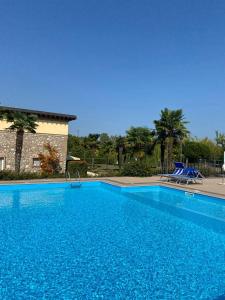 een groot zwembad met blauw water voor een gebouw bij Garda Paradise Country House in Lonato