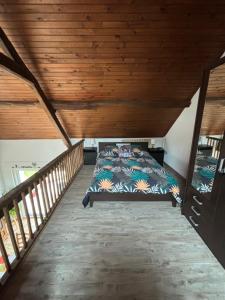 un letto in una stanza con soffitto in legno di Maison avec jardin clos, à quelques pas de la forêt de Tronçais a Saint-Bonnet-Tronçais