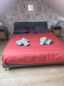 ein großes rotes Bett mit zwei Kissen darauf in der Unterkunft Le Duplex - Massy Centre in Massy