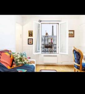 a living room with a couch and a window at Appart Paris vue Tour Eiffel in Paris