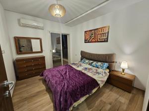 een slaapkamer met een bed, een dressoir en een spiegel bij cité wehat in Tunis