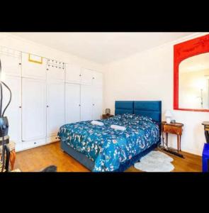 a bedroom with a blue bed and a mirror at Appart Paris vue Tour Eiffel in Paris