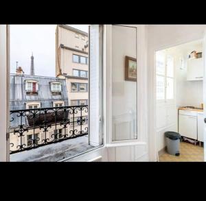 a room with a window with a view of a city at Appart Paris vue Tour Eiffel in Paris