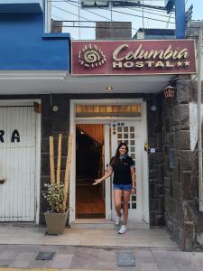 une femme debout à l'entrée d'un restaurant dans l'établissement Hostal COLUMBIA, à Moquegua