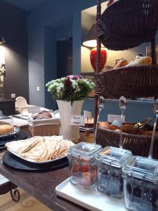 a table with a bunch of bread and baskets of pastries at Be Cottage Hotel in Le Touquet-Paris-Plage