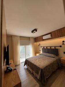 een slaapkamer met een bed en een televisie. bij TERMAS PISMANTA Hotel & Spa in Las Flores
