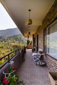a balcony with a view of the mountains at Ecstasy stays in Mukteswar