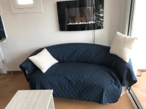 a blue couch in a living room with a table at Stunning sea views from luxury 4 bed apartment close to beach at Cap Ras in Llança