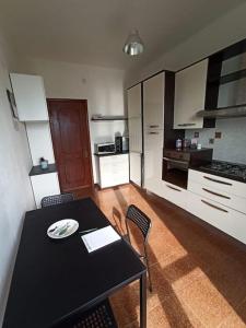 a kitchen with a black table and chairs in a room at Casa ANNA, casa tua in Le Grazie