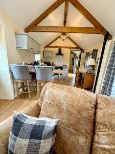 a living room with a couch and a kitchen at Dog friendly barn conversion in the Wye Valley in Mitchel Troy