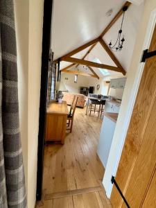 a kitchen and a living room with a table and a kitchen at Dog friendly barn conversion in the Wye Valley in Mitchel Troy