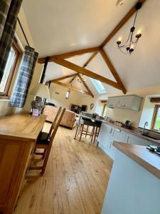 a large kitchen with wooden floors and ceilings with beams at Dog friendly barn conversion in the Wye Valley in Mitchel Troy