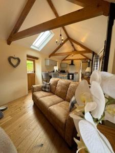 a living room with a couch and a kitchen at Dog friendly barn conversion in the Wye Valley in Mitchel Troy