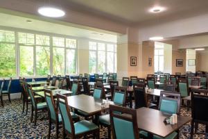 a dining room with tables and chairs and windows at Trecarn Hotel in Torquay