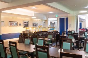 a restaurant with tables and chairs and a bar at Trecarn Hotel in Torquay