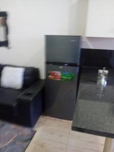 a black refrigerator in a room with a couch at Casa Linda in Maputo