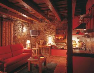 Il comprend un salon avec un canapé rouge et une cuisine. dans l'établissement El Apartamento, à Robledo de la Guzpeña
