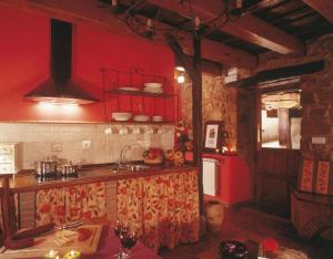 une cuisine aux murs rouges et un comptoir avec évier dans l'établissement El Apartamento, à Robledo de la Guzpeña