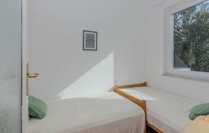 2 camas en una habitación con ventana en Gorgeous Apartment In Nin With Kitchen en Nin