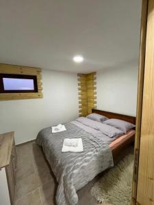 a bedroom with a bed with two towels on it at Apartments Orchidea in Žabljak