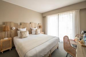 ein Schlafzimmer mit einem großen Bett und einem Fenster in der Unterkunft Hôtel BO & MIA in La Baule