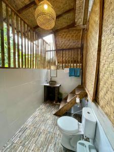 a bathroom with a toilet and a sink at Girang Rinjani Bungalows in Tetebatu