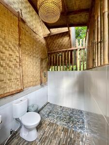 a bathroom with a toilet in a room at Girang Rinjani Bungalows in Tetebatu