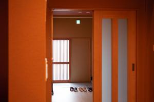 Samurai Suite 2 , 15mins from Kyoto Eki , 5 mins to Arashiyama في كيوتو: باب مفتوح لغرفة فيها حذاء على الأرض