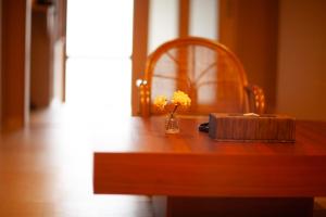a wooden table with a vase of flowers on it at Samurai Suite 2 , 15mins from Kyoto Eki , 5 mins to Arashiyama in Kyoto +20 photos