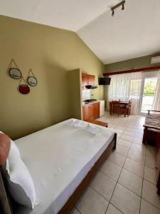 a bedroom with a large bed and a kitchen at Artemis Hotel Apartments in Keramoti +9 photos