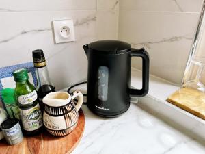 a black kettle on a counter with a cup of coffee at Paradis de Vanves in Vanves