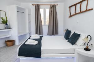 a white bed in a room with a window at Navis studio in Zefiría
