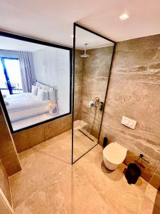 a bathroom with a shower and a toilet in a room at Andon Lapa Hotel & Spa in Sarandë