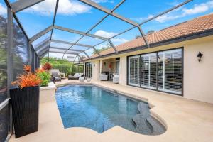 una piscina en una casa con techo de cristal en 4BR Ritzy Marco Home l Lush Pool, en Marco Island