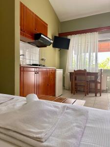 a kitchen with a bed and a table in a room at Artemis Hotel Apartments in Keramotí