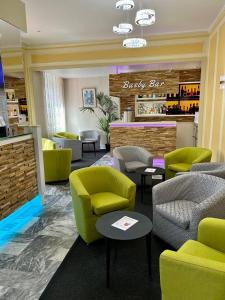 a waiting room with green chairs and a bar at Hotel Busby in Nice