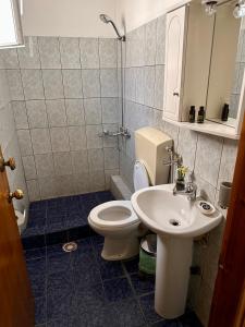 a bathroom with a toilet and a sink at Artemis Hotel Apartments in Keramotí
