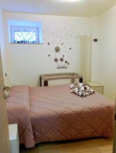 a bedroom with a pink bed and a window at pesa apartment B&B in Ascoli Piceno