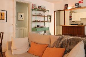a living room with a couch with orange pillows at Cozy and quiet apartment in the 15th in Paris
