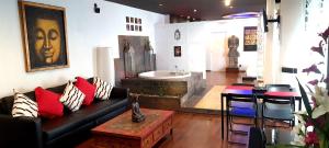 - un salon avec un canapé et une baignoire dans l'établissement Apartamentos con jacuzzi, à Madrid