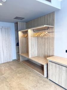 a closet with wooden shelves and wooden hangers at Andon Lapa Hotel & Spa in Sarandë