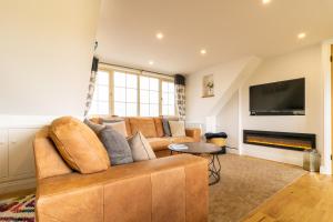 a living room with a couch and a flat screen tv at Picturesque cottage with views 