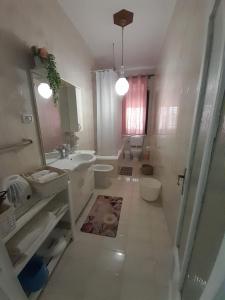 La salle de bains blanche est pourvue d'un lavabo et de toilettes. dans l'établissement Casa Vacanze Ciccinè, à Capaci