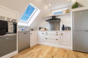 una cucina con armadietti bianchi e una finestra di Picturesque cottage with views 