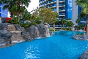 a pool in a resort with blue water at Your Story of Luxury Begins Here in Dubai