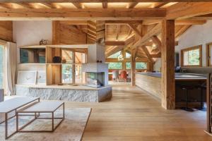 d'un salon ouvert avec une cheminée et des plafonds en bois. dans l'établissement Chalet Contemporain pour 12 personnes avec Sauna, à Vernaison