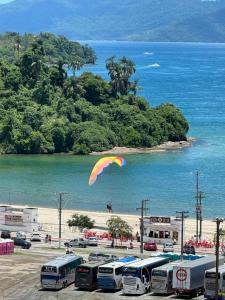 a kite flying over a parking lot next to a beach at Casa Bela Vista in Angra dos Reis
