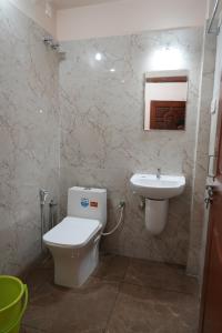 uma casa de banho com um WC e um lavatório em HILL PALACE RESIDENCY COORG em Virajpet