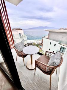 a balcony with a table and chairs and a view of the ocean at Andon Lapa Hotel & Spa in Sarandë