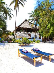 una playa con 2 camas azules en la arena en Blue Palm Zanzibar, en Bwejuu